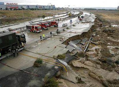 Los Bomberos trabajan en la carretera de Valencia, a la altura del kilómetro 23, donde las intensas lluvias han causado balsas de agua y destrozos en la calzada.