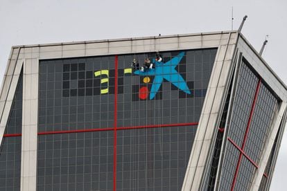 Varios operarios han comenzado poco después de las 8 de la mañana a suprimir el logotipo de Bankia para incorporar, sobre las ventanas más altas del edificio, la imagen de CaixaBank.