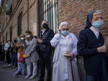 Varias personas hacen cola para votar en un colegio electoral del centro de Madrid, el pasado martes.