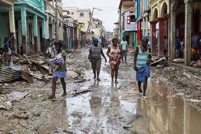 Personas andan por la ciudad de Jeremie, Haití, donde las calles han quedado anegadas por el barro.