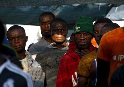 Varios migrantes en uno de los barcos de rescate de M&eacute;dicos sin Fronteras llega a Trapani este domingo.