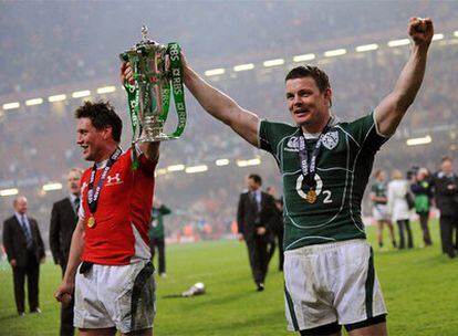 El capitán irlandés Brian O'Driscoll (derecha) alza la copa junto a Ronan O'Gara tras el final del partido frente a Gales, que le ha dado el triunfo en el torneo.
