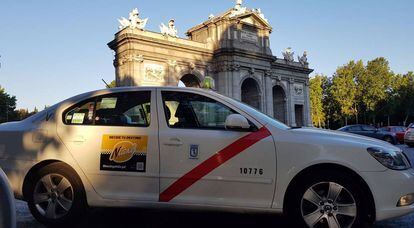 Un taxi agrupado en Ntaxi circula junto a la Puerta de Alcal&aacute;, en Madrid.