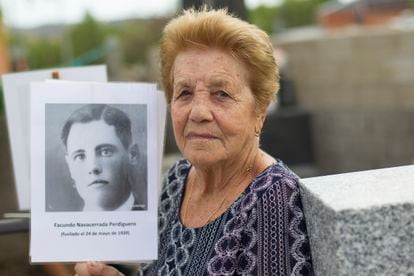 Benita Navacerrada, de 90 años, muestra un retrato de su padre fusilado durante la exhumación de una fosa común en el cementerio de Colmenar Viejo (Madrid) el pasado agosto.