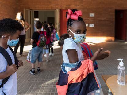 En la imagen, alumnas y alumnos de Primaria se aplican gel hidroalcohólico al entrar en la escuela.
