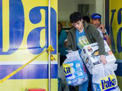Un hombre sale con algunas compras de electrodomésticos en una de las sedes de la cadena de tiendas Daka este lunes 11 de noviembre del 2013, en Caracas (Venezuela).