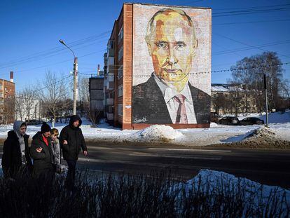 Unos peatones pasan junto a un mural del presidente ruso, Vladímir Putin, en un edificio residencial de la localidad de Kashira (Rusia).