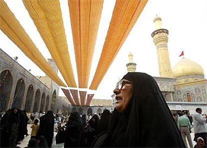 Una iraquí reza en la mezquita de Husein de Kerbala, durante la celebración, ayer, del aniversario del imam Mahdi.