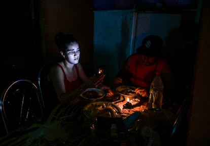 A woman lights up her dinner with her mobile phone during a blackout in Havana in May this year.