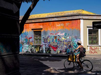 Una mujer pasea en bicicleta por el barrio de Yungay, un barrio tradicional y bohemio del centro de Santiago donde vivirá el presidente Gabriel Boric.