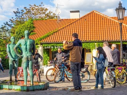 Varios ciclistas observan la escultura de David Cerny, localizada en el Museo Franz Kafka en Praga.