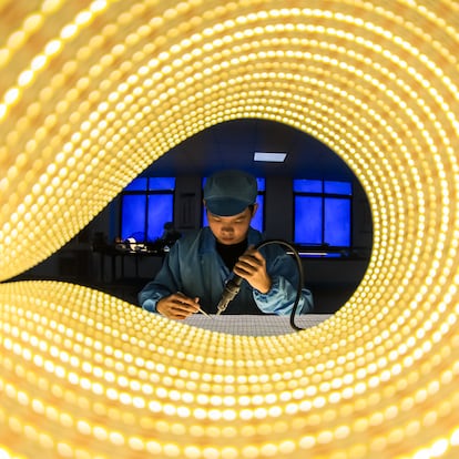 Un empleado trabaja en la línea de producción de tiras de luces LED en una empresa de la provincia china de Jiangxi.
