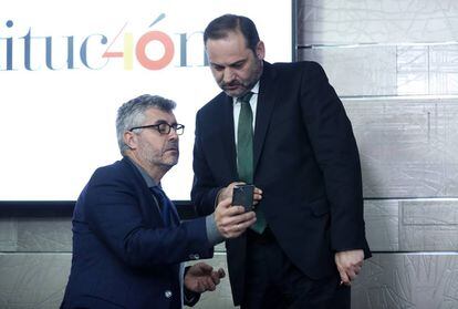 El secretario de Estado de Comunicación, Miguel Ángel Oliver, muestra su móvil al ministro de Fomento, José Luis Ábalos, en La Moncloa.