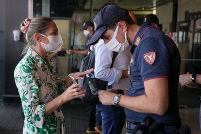 Un poliziotto controlla il certificato verde di una donna alla stazione ferroviaria di Milano Porta Garibaldi.
