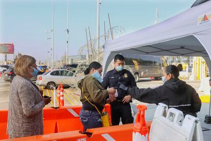 Una mujer muestra su cartilla de vacunación a autoridades estadounidenses en un paso fronterizo en Tijuana, en noviembre de 2021.