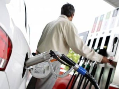 Un hombre reposta en una gasolinera.