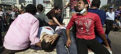 Los manifestantes retiran a los heridos de la plaza Ramsés, de El Cairo.