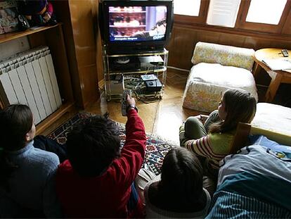 Un grupo de niños observa las emisiones de televisión.