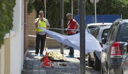 Dos 'mossos', junto al cadáver de un hombre asesinado en el centro de Lleida, en junio.
