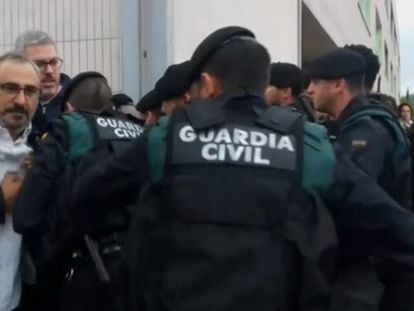 Captura de pantalla de uno de los vídeos mostrados en la sesión del juicio del 'procés' de este martes. En vídeo, La Guardia Civil intenta acceder a un colegio retirando a la gente que se concentra en la puerta el 1-O.