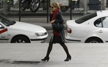 Una mujer pasea por el centro de Madrid mientras habla por el m&oacute;vil.