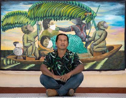 El artista Brus Rubio, pintor indígena, delante de uno de sus cuadros sobre la pandemia.