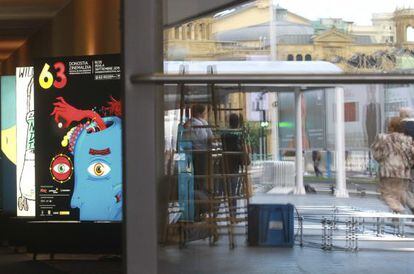 Preparativos de la 63ª edición del Festival de San Sebastián, ante una de sus sedes, el Teatro Victoria Eugenia (detrás). En primer término, el cartel de este año.