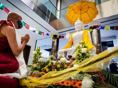 Un monje budista se arrodilla frente al buda en la ceremonia civil de su recepción en el Puerto de Valencia este martes
