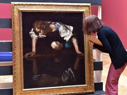Un restaurador italiano examina la pintura 'Narciso' del maestro barroco italiano Caravaggio.