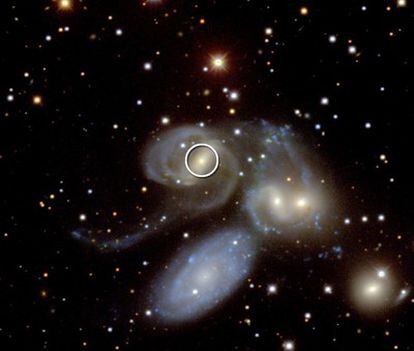 Imagen en visible de la fusión de tres galaxias en el sistema NGC 7319 con el agujero negro activo marcado por un círculo.