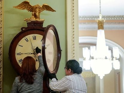 Dos trabajadoras del Capitolio ajustan un reloj, el 21 de enero de 2020.