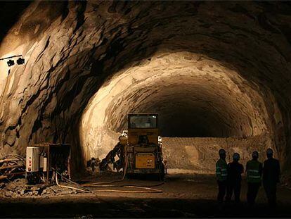 A la derecha, un grupo de personas observa el tercer túnel de Guadarrama.