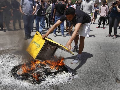 Un grup de treballadors cremen motxilles davant la seu de Glovo.