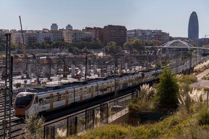 Un tren de cercanías pasa junto a las obras de la estación del AVE de Sagrera en Barcelona.