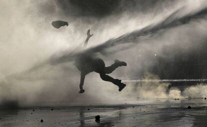 Un manifestante recibe el golpe de un chorro de agua durante una reciente manifestación en Santiago. / FERNANDO LLANO (AP)