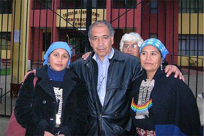 Frente a la cárcel, Roberto Troncoso, padre de la teóloga en huelga de hambre, entre dos mujeres mapuches.