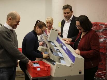 El l&iacute;der del SPD y alcalde de Hamburgo, Olaf Scholz (izq.), y la l&iacute;der del partido en el Bundestag, Andrea Nahles (dch.),  durante el recuento de votos en el refer&eacute;ndum sobre la gran coalici&oacute;n celebrado entre las bases. (AP Photo/Markus Schreiber)