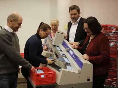 El líder del SPD y alcalde de Hamburgo, Olaf Scholz (izq.), y la líder del partido en el Bundestag, Andrea Nahles (dch.),  durante el recuento de votos en el referéndum sobre la gran coalición celebrado entre las bases. (AP Photo/Markus Schreiber)