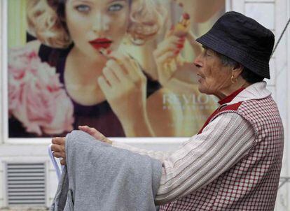 Una mujer vende camisetas en un mercadillo en Malveira.
