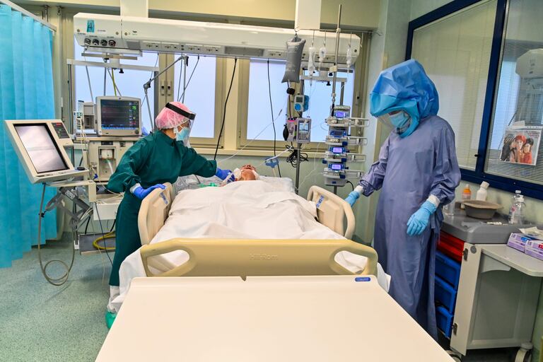 Dos enfermeras con el equipo de protección atiende a un paciente con covid-19, en la UCI del hospital Tor Vergata, en Roma.