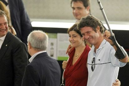 Albert Vilalta, junto a su mujer, saluda a su llegada al aeropuerto del Prat.