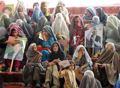 Un grupo de mujeres, algunas con <i>burka,</i> exhibe pancartas de Hamid Karzai durante un mitin en Kandahar.