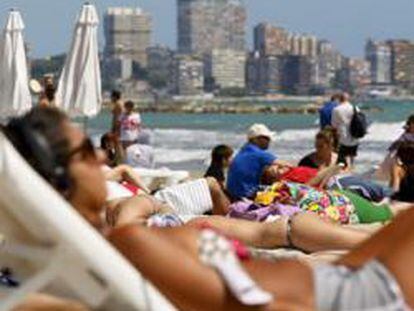 Turistas disfrutan del sol y las altas temperaturas en la playa del Postiguet de Alicante.