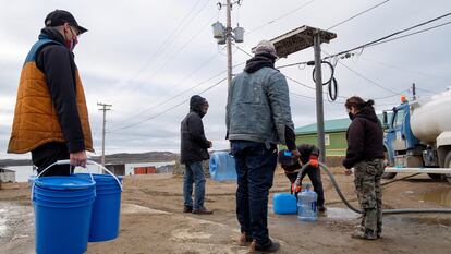 Un grupo de personas hace fila para recolectar agua de un camión cisterna el jueves.