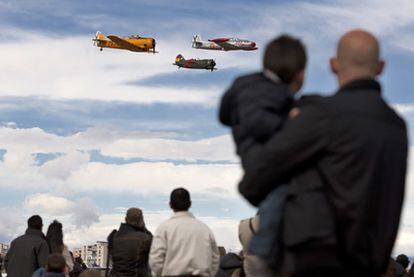 Unos espectadores observan el vuelo de tres aviones de la colección de la Fundación Infante de Orleans, en Cuatro Vientos.