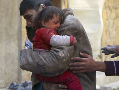 Un joven abraza a su hermana salvada de los escombros de un edificio atacado este viernes en Alepo.