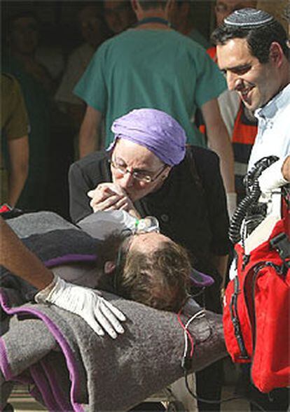 Una mujer israelí acompaña a un familiar tiroteado ayer por un palestino.