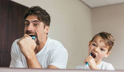 Un padre se lava los dientes con su hijo. 