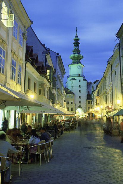 Terrazas en la calle peatonal que lleva a la puerta de San Miguel (al fondo), en Bratislava.