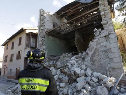 Un bombero junto a los escombros de un edificio en el Visso (Italia).